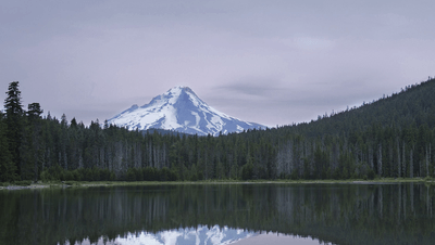 A mountain lake at dusk, the view panning slowly from left to right.