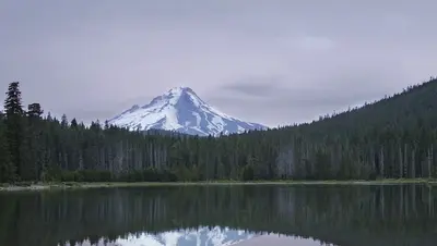 A mountain lake at dusk, the view panning slowly from left to right.